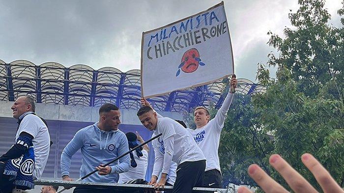 Aksi Davide Frattesi membentangkan spanduk sindiran untuk Tifosi AC Milan, dalam parade perayaan Scudetto Inter Milan, Minggu (28/4/2024).