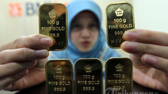 HARGA EMAS ANTAM - Customer service Bank BNI Syariah menunjukkan logam mulia emas ukuran 100 gram di banking hall di Jakarta Selatan, Senin (16/12/2013). Jelang lebaran Idul Fitri 1446 Hijriah atau tahun 2025, terjawab sudah berapa harga 1 gram emas sekarang pada Kamis 27 Maret 2025 hari ini.
