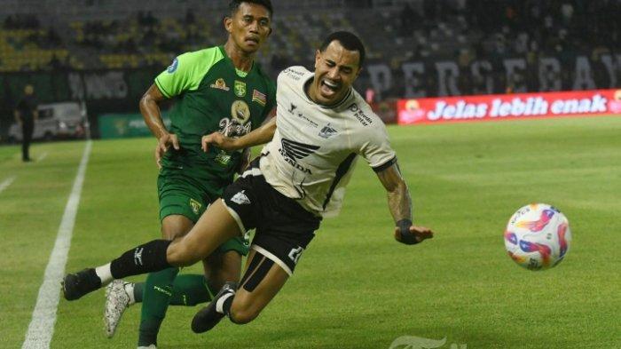 SETIA BARENG PSM - Pemain Persebaya Catur P (kiri) berusaha mencuri bola dari pemain PSM Makassar Victor Luiz (kanan) pada pertandingan yang berlangsung di Stadion Gelora Bung Tomo (GBT) Surabaya, Selasa (23/10/2024) malam.  2024/2025. SURYA/HABIBUR ROHMAN