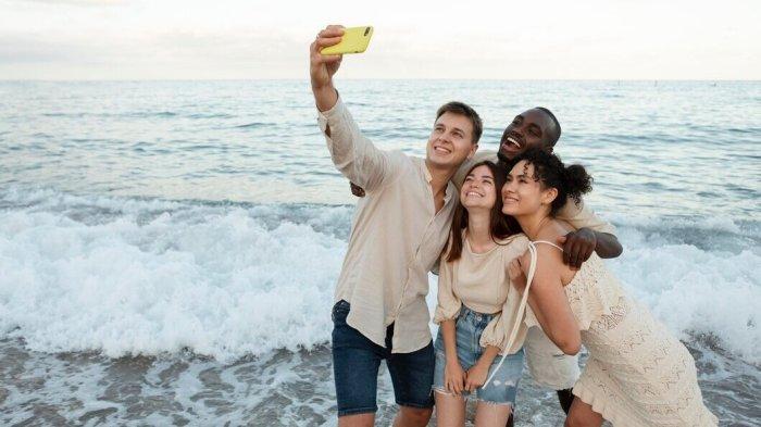 PANTUN LIBURAN - Potret liburan bersama teman di pantai dari Freepik.com, Kamis (8/5/2025). Lihat kumpulan pantun liburan berikut ini, bisa jadi kode keras ajak keluarga atau sahabat healing di pantai saat libur sekolah.