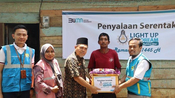 Penyalaan listrik penerima bantuan Light Up The Dream kepada Wagiran (kedua kanan) yang selama 3 tahun hidup dengan menyalur listrik dari tetangga beserta penyerahan bantuan sembako oleh Asisten 2 Kabupaten Bungo Saiful Azhar (tengah), dan Manager UP3 Muara Bungo Agung Pratomo (kanan).