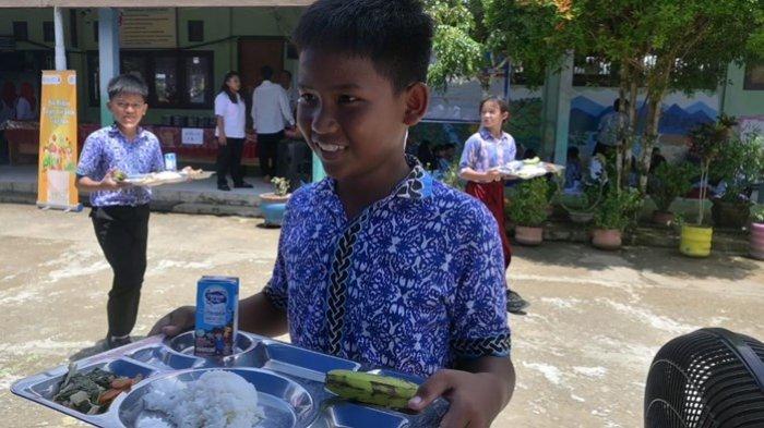 Uji coba program makan bergizi gratis kerja sama Pemkab Malinau dan Pemprov Kaltara di Malinau, Kalimantan Utara, Rabu (16/10/2024). Tampak siswa memegang menu program makan bergizi gratis. (TRIBUNKALTARA.COM / MOHAMMAD SUPRI)