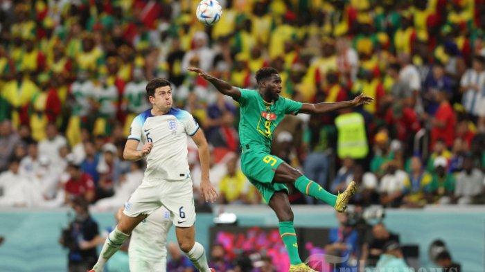 Penyerang Senegal Boulaye Dia (kanan) berebut bola dengan bek Inggris Harry Maguire selama pertandingan sepak bola babak 16 besar Piala Dunia Qatar 2022 antara Inggris dan Senegal di Stadion Al-Bayt di Al Khor, utara Doha pada 4 Desember 2022. (Photo by Adrian DENNIS / AFP)