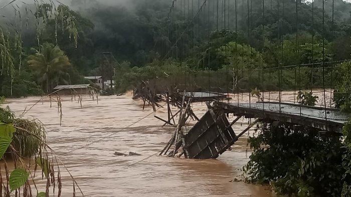 Warga memasang kayu sebagai jembatan sementara, buntut jembatan menuju arah perbatasan tersebut hanyut akibat banjir,