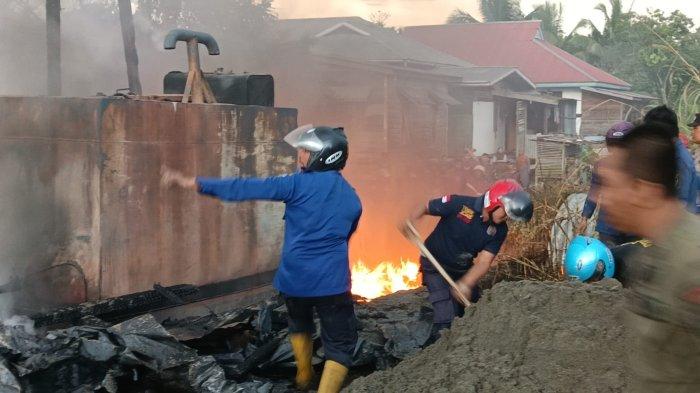 Petugas masih berupaya memadamkan api karena merupakan material mudah terbakar, BBM dan plastik drum. Tampak pula api berkobar di sebelah diduga tangki penyimpanan BBM. Pemadam menggunakan pasir untuk membantu memadamkan api, Rabu (12/7/2023) sore.