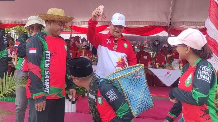 Bupati Kotim Halikinnor memberikan bonus kepada Camat Teluk Sampit sebagai bentuk apresiasi menggerakan warganya untuk memeriahkan peringatan HUT RI ke-78 dengan pengibaran Bendera Merah Putih sepanjang 78 meter di Pantai Ujung Pandaran.
