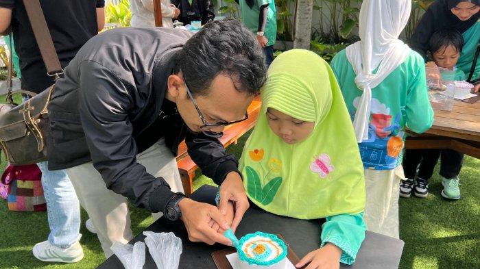 Salah seorang peserta Kids Playdate sedang menghias kue dengan Korean Style Cake bersama ayah dalam 