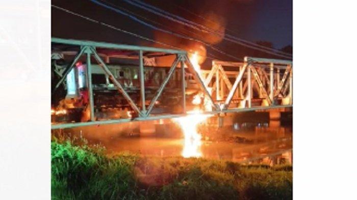 Api masih berkobar di tengah jembatan Sungai Banjir Kanal Barat Semarang usai tabrakan kereta api dan truk kontainer, malam ini.