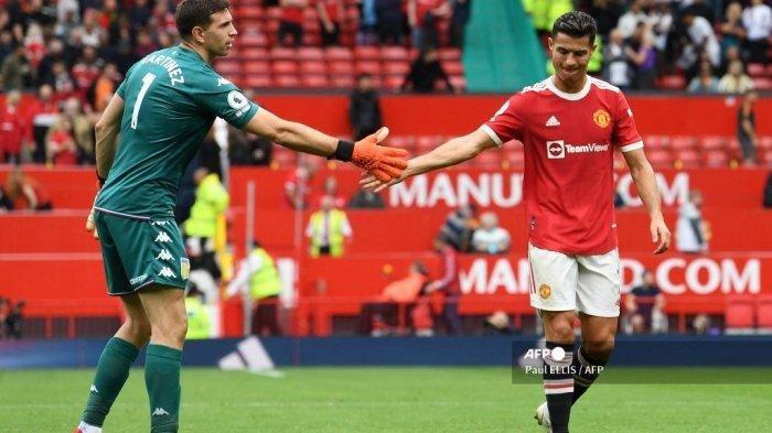Penjaga gawang Aston Villa asal Argentina Emiliano Martinez (kiri) bergandengan tangan dengan striker Portugal Manchester United Cristiano Ronaldo setelah pertandingan sepak bola Liga Inggris antara Manchester United dan Aston Villa di Old Trafford di Manchester, barat laut Inggris, pada 25 September 2021.