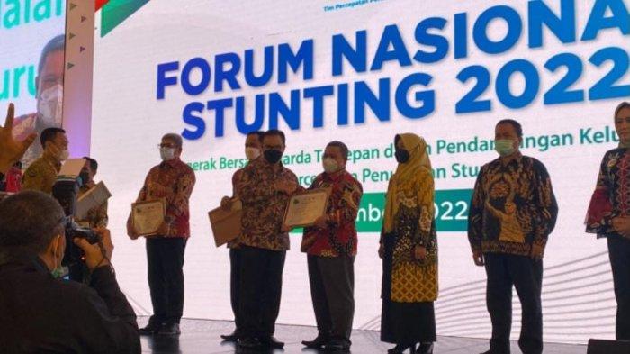 Plh Sekda Kobar Juni Gultom saat menerima penghargaan dari BKKBN atas upaya percepatan penurunan stunting di daerah pada Forum Nasional Stunting 2022 di Jakarta.