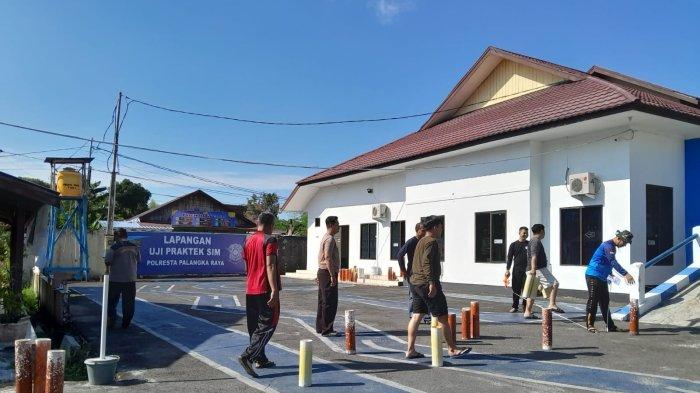 Iptu Hartono Kanit Regident Satlantas Polresta Palangkaraya bersama rekannya melakukan pembuatan Lapangan Uji praktik SIM yang baru, di Polresta Palangkaraya, Sabtu (5/8/2023).