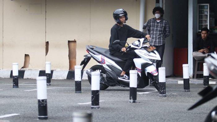 Ilustrasi seorang pengendara sepeda motor yang mengikuti ujian praktik SIM.