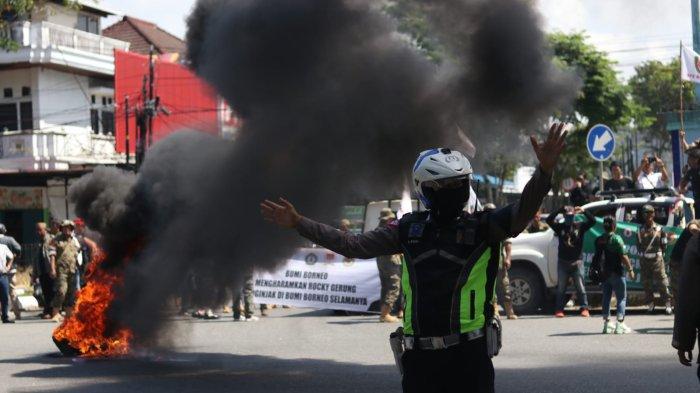 Polisi mengatur lalu lintas di persimpangan Tugu KB Balikpapan di tengah berlangsungnya aksi demo oleh para ormas, Rabu (2/8/2023). 