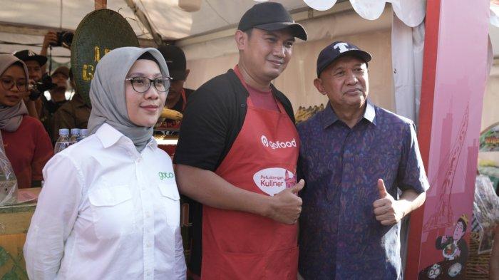 Perwakilan Mitra Usaha GoTo, dari GoFood, Sulistyono - pemilik kuliner Juara Lokal Solo Leker Gajahan Bapak Fathoni Jr. (tengah) berfoto bersama di sela-sela kunjungan Menteri Koperasi dan UKM, Teten Masduki, yang turut didampingi oleh Director of External Affairs GoTo, Nila Marita pada Perayaan Hari UMKM Nasional 2023.