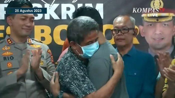 Kedua ayah dari bayi tertukar saling berpelukan usai hasil tes DNA diumumkan.