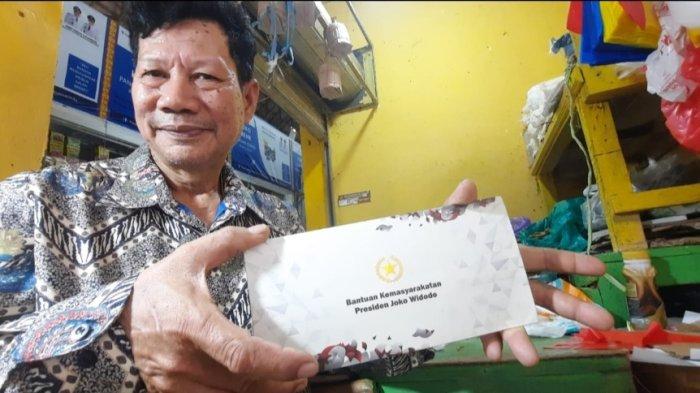 Ahmad Rauf penjual Ikan Asin mendapatkan hadiah amplop dari Presiden Jokowi di Pasar Merdeka, yang terletak di Jalan Merdeka, Sungai Pinang Dalam, Sungai Pinang, Samarinda, Kamis (21/9/2023). TRIBUN KALTIM.CO/NEVRIANTO HARDI PRASETYO