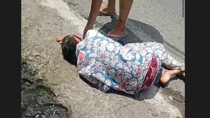 Rika Yunita, sedang histeris di pinggir jalan setelah bayinya tewas di dalam baskom mandi.