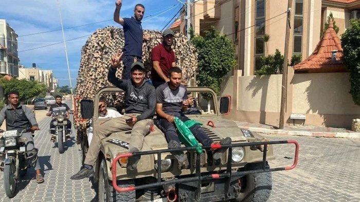 Hamas Palestina menaiki kendaraan militer Israel yang disita oleh orang-orang bersenjata Palestina yang menyusup ke wilayah Israel selatan di Jalur Gaza selatan, 7 Oktober 2023. Mengenal lebih dekat kelompok pejuang Hamas yang menyerang Israel, ketahui sejarah berdirinya.