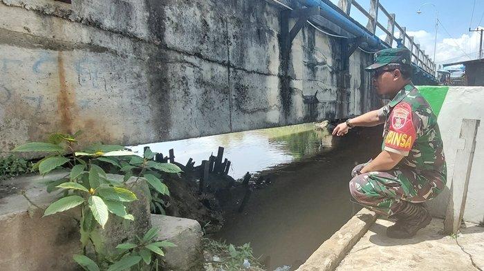 Babinsa Kelurahan Lok Bahu Sertu Sulistiyo saat menunjukan lokasi ditemukan jasad dua bocah yang tenggelam di Sungai Karang Asam Besar, Jalan Revolusi Samarinda, Jumat (17/11/2023). Di lokasi ada tanda gelas berisi kepiting.