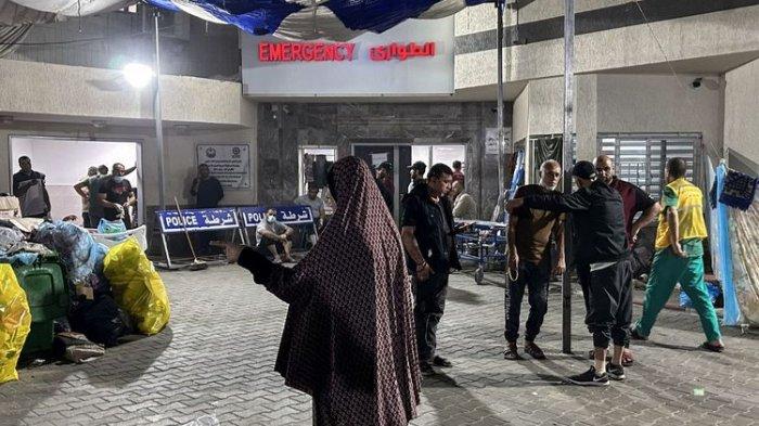 Orang-orang berdiri di luar bangsal darurat rumah sakit Al-Shifa di Kota Gaza pada 10 November 2023, di tengah pertempuran yang sedang berlangsung antara Israel dan gerakan Hamas Palestina. Pertempuran sengit terjadi di dekat rumah sakit Al-Shifa, dan Israel mengatakan bahwa mereka telah menewaskan puluhan militan dan menghancurkan terowongan-terowongan yang menjadi kunci bagi Hamas untuk bertempur. Israel melancarkan serangan ke Gaza setelah para pejuang Hamas menyerbu perbatasan yang sangat dimiliterisasi pada tanggal 7 Oktober, menewaskan 1.400 orang, sebagian besar warga sipil, dan menyandera sekitar 240 orang.