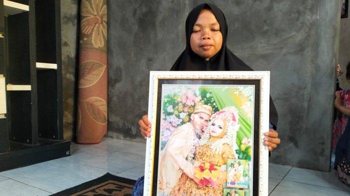 Suwarni saat menunjukkan foto pernikahannya bersama almarhum suaminya, Suprianda (27) yang tewas diterkam harimau milik majikannya di Samarinda, Sabtu (18/11/2023) lalu.
