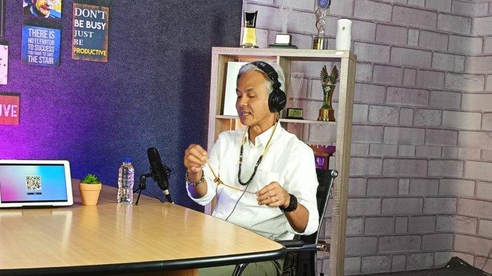 Capres Ganjar Pranowo pamer kalung pemberian masyarakat Dayak kepada Pemimpin Redaksi Tribun Kaltim Ibnu Taufik Juwariyanto dalam podcast Mata Lokal Memilih, Kamis (7/12/2023) di Studio Tribun Kaltim. 