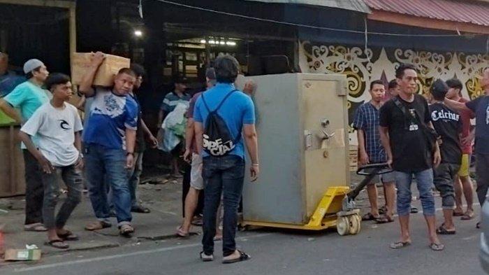 Para pedagang emas sedang memindahkan brankas, Senin (29/12/2023). 