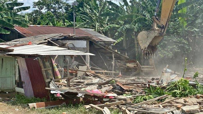 PEMBONGKARAN RUMAH JUNAEDI - Satu unit eksavator dikerahkan untuk meratakan rumah yang ditinggali pelaku pembunuhan di Desa Babulu Laut, Kabupaten Penajam Paser Utara, Kalimantan Timur, Sabtu (10/2/2024). Kepala Desa Babulu Laut, H. Ismail Subli, menjelaskan, alasan pembongkaran karena permintaan warga dan ada kesepakatan dari keluarga pelaku dan korban.  