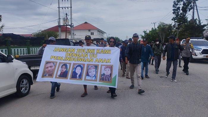 VONIS TERDAKWA JUNAEDI - Sejumlah warga dari pihak keluarga korban melakukan longmarch dari PN PPU ke Kantor Sekretariat DPRD PPU, Rabu (13/3/2024). Para masyarakat yang ikut hadir di luar Pengadilan Negeri Penajam Paser Utara, lalu saling bersahutan, menyoraki bahwa putusan tersebut tak adil.