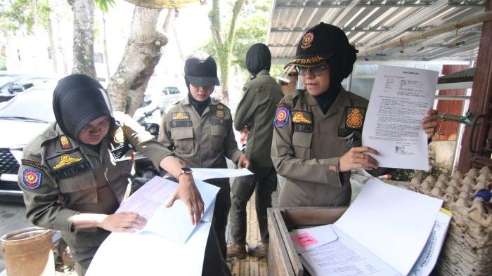 RAZIA POM MINI - Personel dari Satpol PP Balikpapan tengah mencatat kelengkapan data dari pelaku usaha Pom Mini BBM di Balikpapan, Kalimantan Timur pada Kamis (25/4/2024). Dalam penertiban ini, para personel gabungan dibagi menjadi tiga tim untuk menyasar tiga lokasi kawasan sasaran razia Pom Mini.