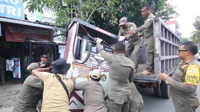 RAZIA POM MINI - Petugas Satpol PP kota Balikpapan mengangkut mesin dispenser Pom Mini menggunakan truk untuk selanjutnya diamankan di kantor Satpol PP Balikpapan, Kalimantan Timur pada Kamis (25/4/2024) pagi. Pelaku usaha Pom Mini BBM di Balikpapan ingin, penertiban Pom Mini seperti ini dilakukan secara merata dan menyeluruh di kota Balikpapan agar tidak menimbulkan kecemburuan sosial.