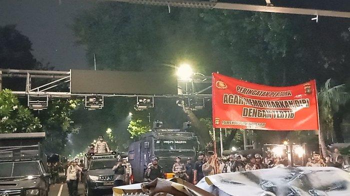 Polisi memberikan peringatan pada massa aksi di samping Patung Arjuna Wijaya, Gambir, Jakarta Pusat, Senin (22/7/2024)