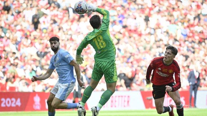 Gelandang Manchester United Argentina #17 Alejandro Garnacho berlari mengejar bola yang gagal dihentikan oleh kiper Manchester City Jerman #18 Stefan Ortega (tengah) selama pertandingan sepak bola final Piala FA Inggris antara Manchester City dan Manchester United di stadion Wembley, di London, pada Mei 25 Agustus 2024. (Photo by JUSTIN TALLIS / AFP)