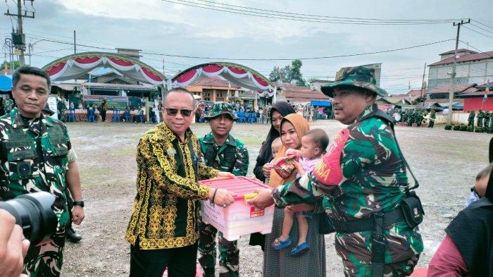 TMMD DI PASER - Asisten Pemerintahan dan Kesejahteraan Rakyat Paser, Romif Erwinadi mewakili Bupati Paser, Fahmi Fadli saat menerima berkas dari Dandim 0904/Paser, Letkol Inf Ary Susetyo sebagai tanda berakhirnya pelaksanaan TNI Manunggal Membangun Desa (TMMD) ke-121, yang berlangsung di lapangan Kecamatan Batu Sopang, Kabupaten Paser, Kalimantan Timur, Kamis (22/8/2024).