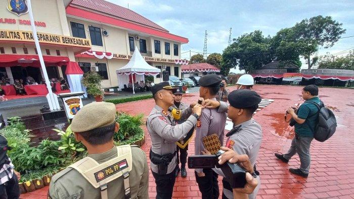 Kapolres Bontang AKBP Alex Frestian Lumban Tobing menyematkan pita sebagai tanda simbolis, Operasi Mantap Praja Mahakam 2024 di Kota Bontang mulai diberlakukan, jelang Pilkada serentak, di Halaman Mapolres Bontang, Jumat (23/8/2024). TRIBUNKALTIM.CO/MUHAMMAD RIDWAN