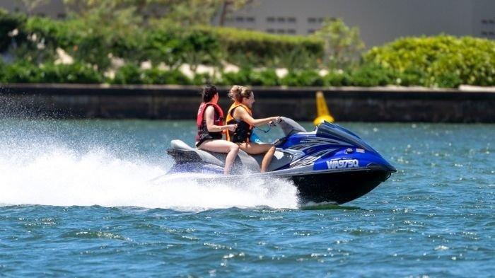 Ilustrasi wisatawan bermain jetski yang menantang.