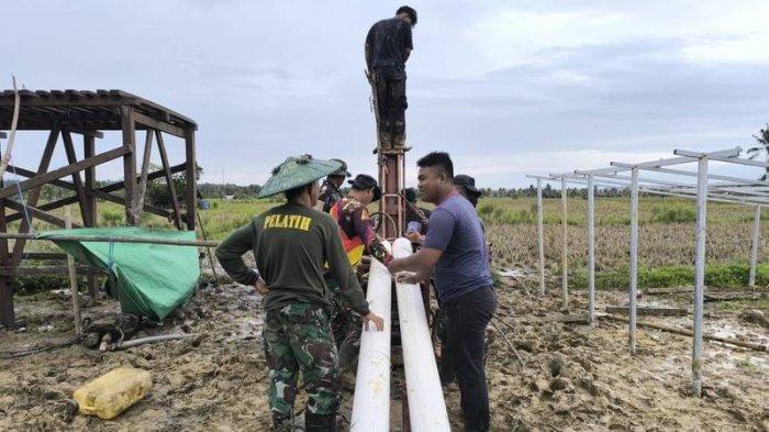 GOTONG ROYONG - Anggota Satgas TMMD bersama warga Desa Kertabuana bersinergi dan bergotong royong dalam mempersiapkan sarana pendukung TMAB pertanian berupa pipa dengan diameter yang besar yang nantinya akan difungsikan sebagai casing pipa di sumur bor. (HO KODAM VI MULAWARMAN)