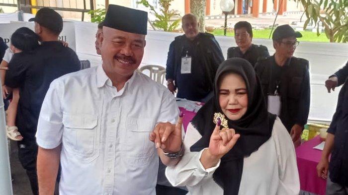 Calon Bupati Kutai Kartanegara Edi Damansyah bersama istri memperlihatkan jari yang telah dicelup tinta ungu, tanda telah menyalurkan hak pilihnya pada Pilkada Kukar 2024 di TPS 022 Kelurahan Timbau, Kecamatan Tenggarong, Kukar, Kalimantan Timur, Rabu (27/11/2024).