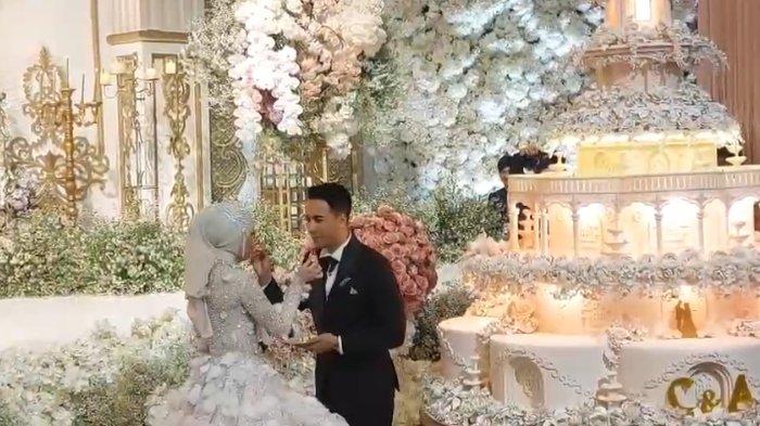 MOMEN MESRA PENGANTIN - Kedua mempelai, Cindara Rahmad dan Abdurahman, saling memberi suapan kue pengantin di acara resepsi di Gedung BSCC Dome, Balikpapan, Kalimantan Timur, Sabtu (14/12/2024). Pernikahan anak Walikota Balikpapan ini berlangsung mewah dan menjadi sorotan publik. TRIBUNKALTIM.CO/ARY NINDITA INTAN