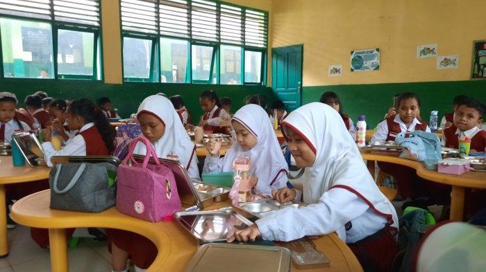 MAKAN BERGIZI GRATIS - Sejumlah siswa SDN 010 Balikpapan Selatan mengkomsumsi makanan bergizi gratis yang telah di sediakan, Selasa (18/2). Pelaksanaan dihari kedua berjalan lancar dengan total penerima manfaat 809 siswa. (TRIBUNKALTIM.CO / RAYNALDI PASKALIS)