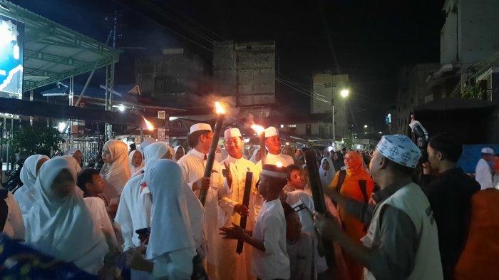 PAWAI OBOR RAMADHAN - Panitia penyelenggara membawa obor di depan rombongan anak-anak yang menempati urutan pertama. Selasa (25/2/2025). Pawai obor ini diikuti oleh ratusan peserta dari lingkungan masjid Jami Assu'adaa.(TRIBUNKALTIM.CO /Raynaldi Paskalis)