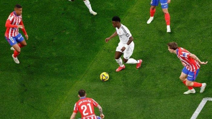 DIKEPUNG - Pemain Real Madrid Vinicius Junior mendapat kawalan ketat saat tampil di laga Derby Madrid antara Real Madrid vs Athletico Madrid pada Minggu (9/4/). (Laman Resmi Real Madrid)