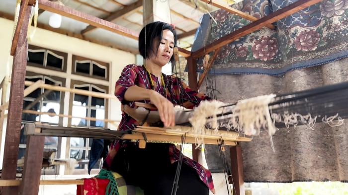 Erna Juwita, tokoh perempuan dari Kelompok Adat Rumah Songket Mempawah tengah menenun kain songket secara tradisional. Aktivitas ini merupakan bagian dari pengembangan UMK binaan PLN yang berkontribusi dalam pelestarian budaya serta membuka peluang ekonomi masyarakat, khususnya perempuan, di wilayah Kalimantan Barat.