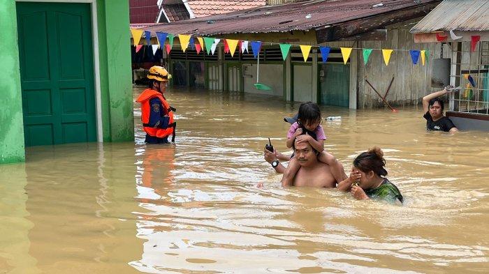 EVAKUASI - Banjir yang merekam kawasan permukiman warga di Balikpapan Selatan. Tampak keluarga yang tengah berupaya mengevakuasi diri pada Jumat (9/8/2024).