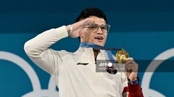 Kisah Rizky Juniansyah yang berpose di podium setelah pertandingan angkat besi putra kelas -73kg di Olimpiade Paris 2024 di South Paris Arena, Paris, pada 8 Agustus 2024.