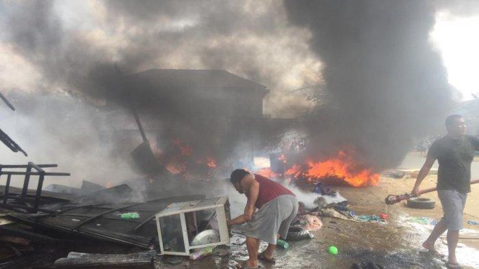 Para petugas pemadam kebakaran dan di bantu dengan warga berusaha memadamkan api, di jalan A Yamin, Barong Tongkok, Kurai Barat, Selasa (25/12/2018).