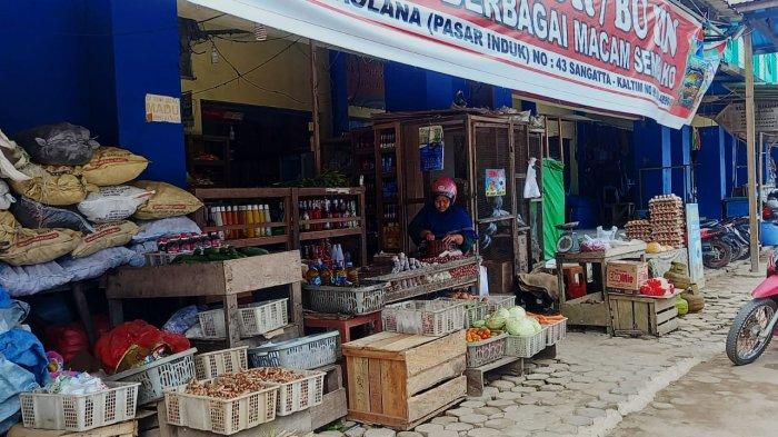 Pengunjung Pasar Induk Pare sedang memperhatikan informasi tentang perubahan retribusi