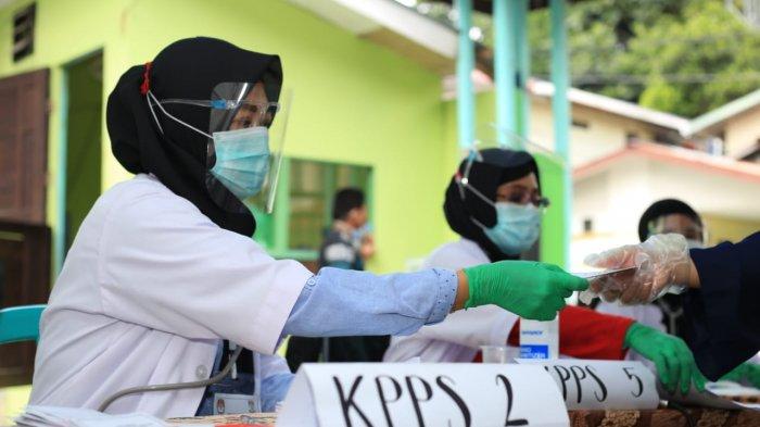 Petugas KPPS TPS 002 Mekar Sari mengenakan kostum tenaga kesehatan lengkap dengan stetoskop untuk menarik minat pemilih, Rabu (9/12/2020). TRIBUNKALTIM.CO/DWI ARDIANTO
