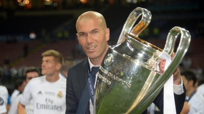 Pelatih Real Madrid, Zinedine Zidane, mengangkat trofi Liga Champions di Stadion San Siro, Milan, pada Sabtu (28/5/2016).