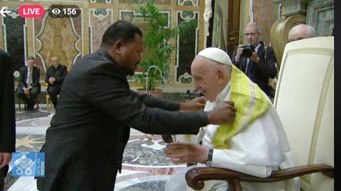 Ary Bargon dari Timor Leste mengalungi Paus Fransiskus dengan selendang khas Timor Leste dalam pertemuan mewakili komedian Asia di Vatikan, Jumat 14 Juni 2024.